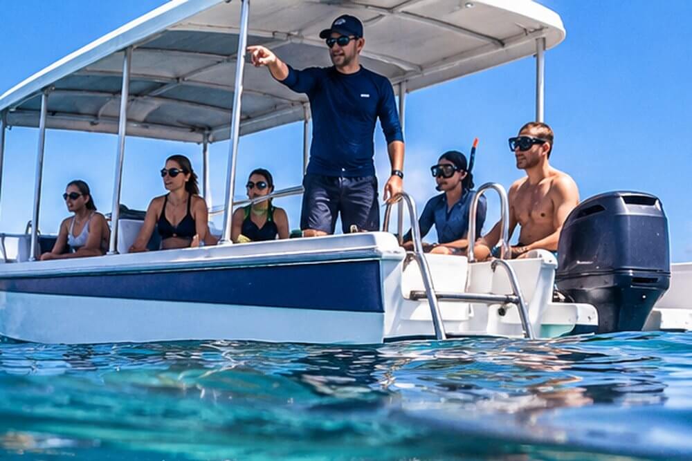 Przewodnik objaśnia zasady snorkelingu uczestnikom wycieczki łodzią